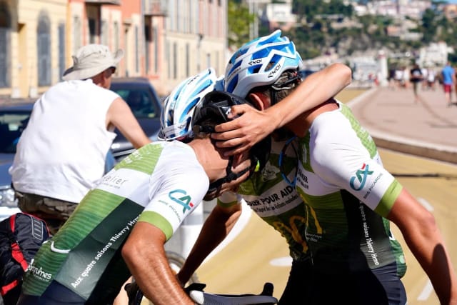 Deux cyclistes s'étreignent à l'arrivée, à Nice