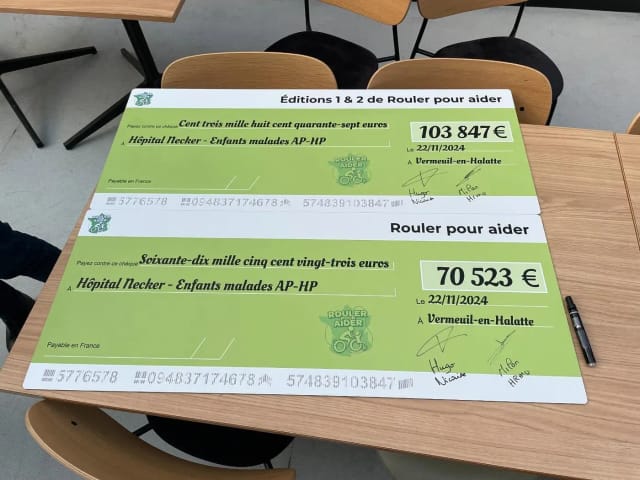 Les deux chèques signés, posés sur une table